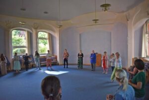 Menschen stehen im Kreis im großen Saal